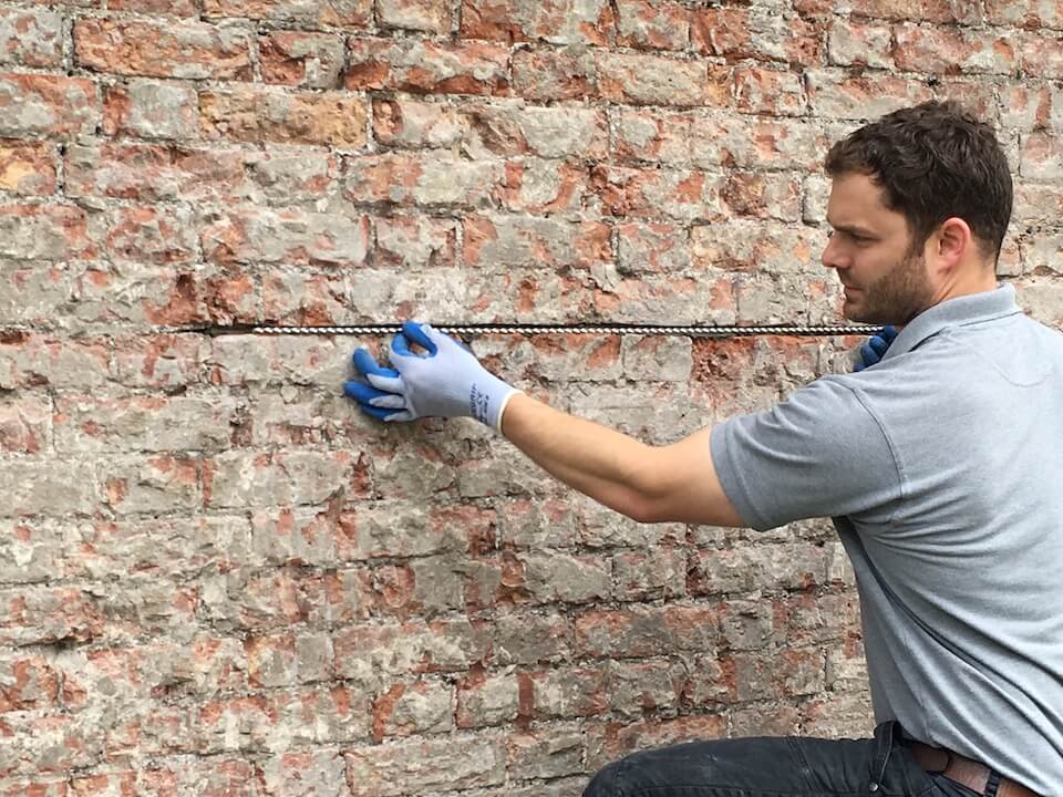 A helical bar being fitted to a wall