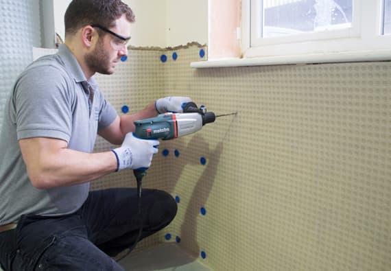 A man installing a PermaSEAL damp proofing membrane