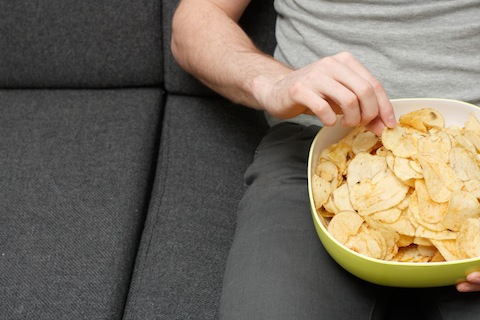 man eating snacks in basement cinema